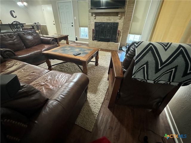 living room with a fireplace, wood-type flooring, and a healthy amount of sunlight