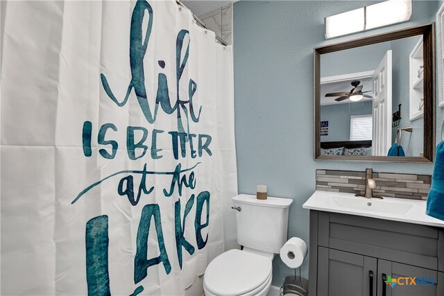 bathroom featuring backsplash, vanity, a shower with shower curtain, toilet, and ceiling fan