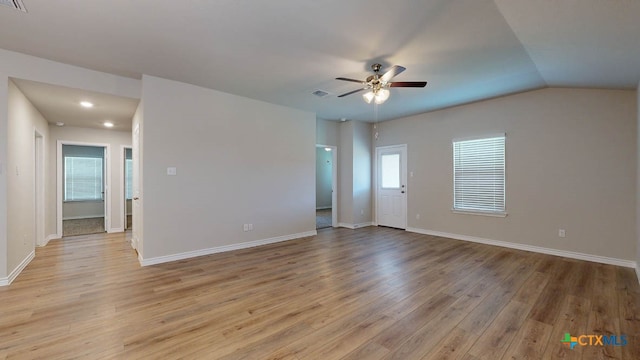 spare room featuring light hardwood / wood-style flooring, lofted ceiling, and ceiling fan