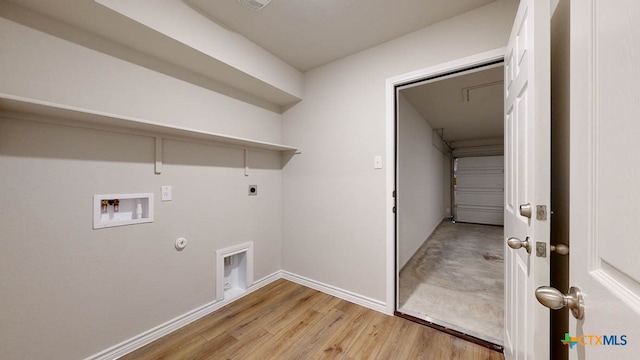 washroom with hookup for an electric dryer, light hardwood / wood-style flooring, washer hookup, and hookup for a gas dryer