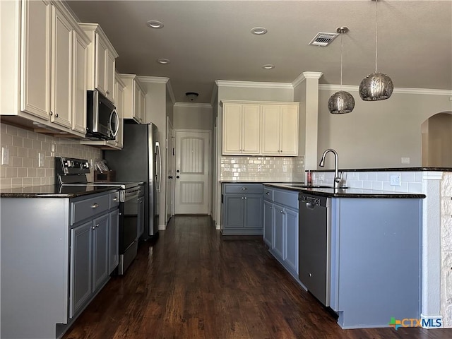 kitchen with white cabinetry, sink, stainless steel appliances, and decorative light fixtures