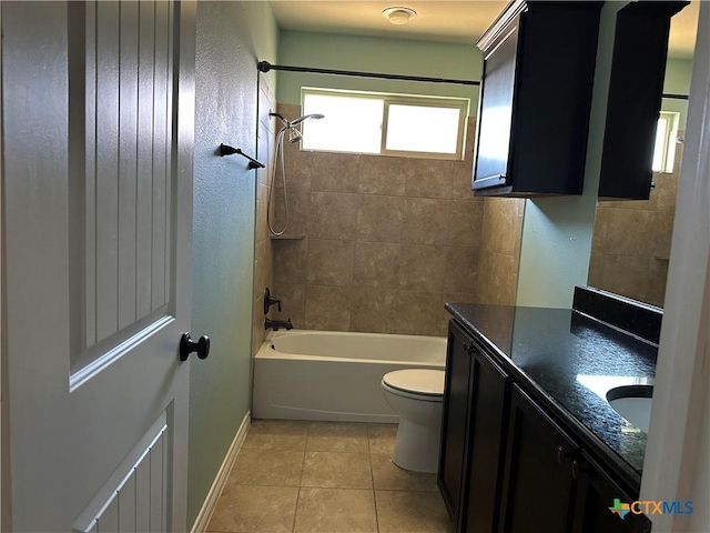 full bathroom featuring tile patterned flooring, vanity, tiled shower / bath combo, and toilet