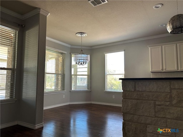 unfurnished dining area featuring crown molding, a wealth of natural light, and dark wood-type flooring