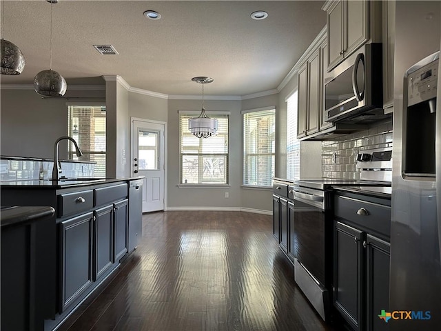 kitchen featuring appliances with stainless steel finishes, decorative light fixtures, plenty of natural light, and sink