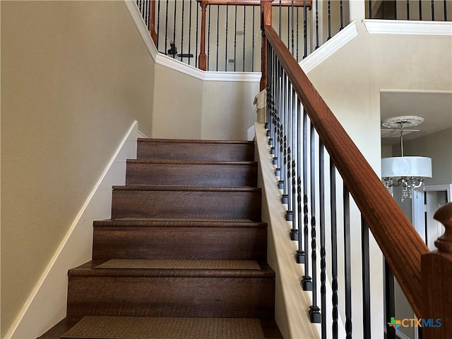 stairs featuring a chandelier