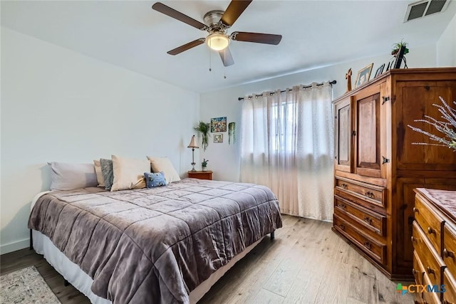 bedroom with light wood-style flooring, visible vents, and ceiling fan