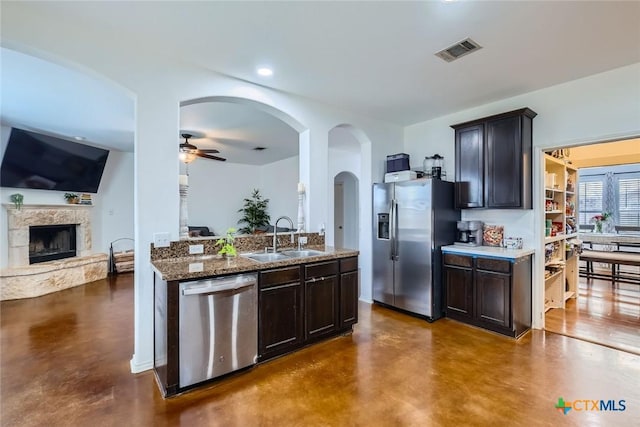 kitchen featuring a fireplace, visible vents, appliances with stainless steel finishes, a sink, and concrete floors