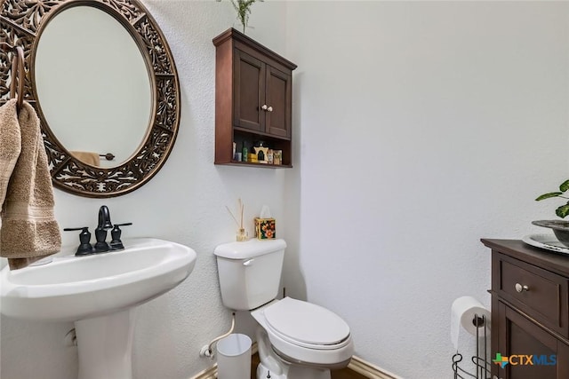 half bathroom featuring a sink and toilet