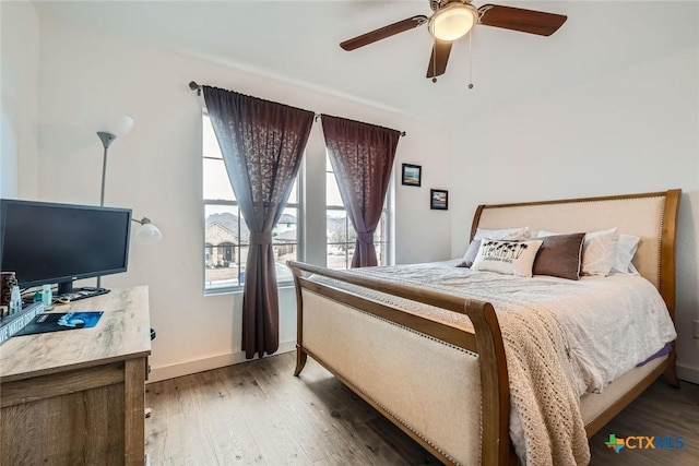 bedroom with wood-type flooring, ceiling fan, and baseboards