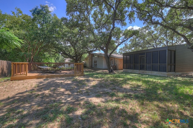 view of yard with a sunroom and a wooden deck