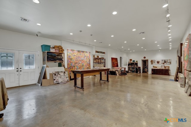 rec room featuring concrete flooring and french doors