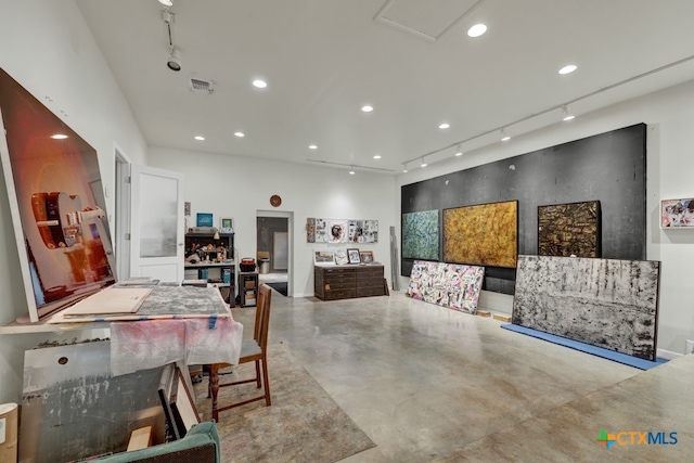 dining area featuring concrete flooring and rail lighting