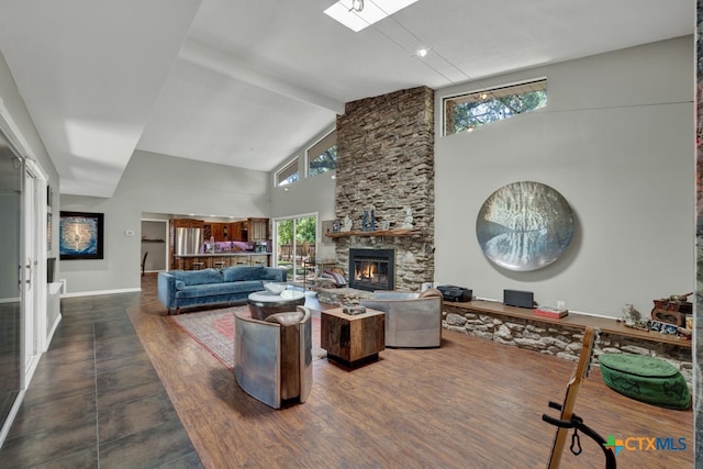 living room with a stone fireplace, plenty of natural light, high vaulted ceiling, and wood-type flooring