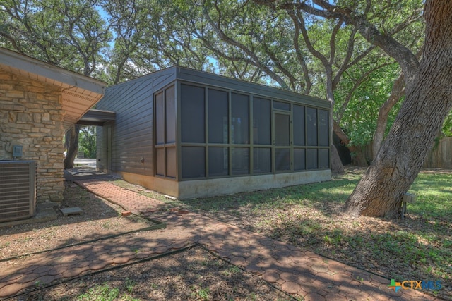 view of outdoor structure with a sunroom and cooling unit