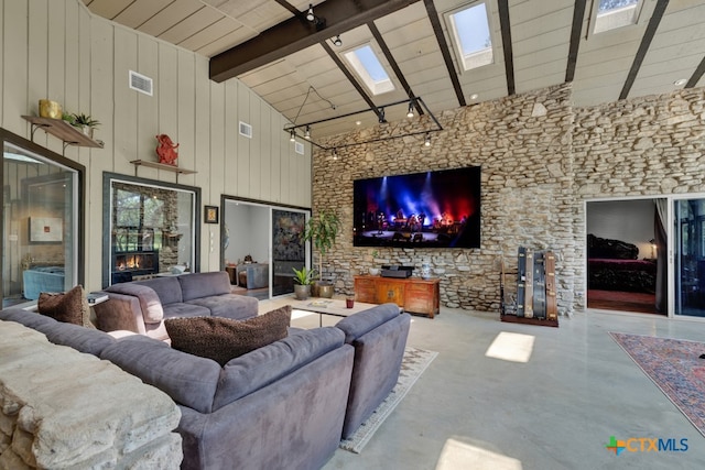 living room featuring wooden ceiling, wood walls, beamed ceiling, a skylight, and high vaulted ceiling