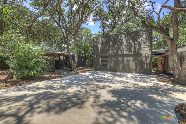 view of home's exterior featuring a garage, an outbuilding, and a carport