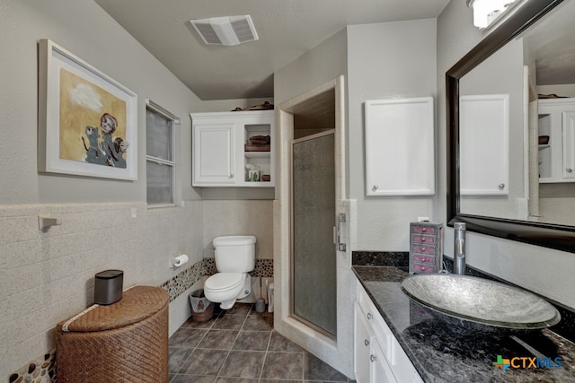 bathroom featuring tile walls, vanity, an enclosed shower, tile patterned flooring, and toilet