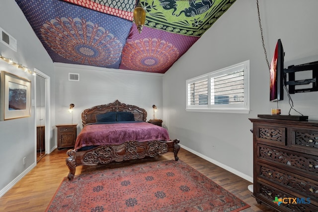 bedroom featuring hardwood / wood-style floors and lofted ceiling