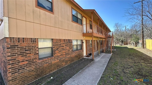 view of home's exterior featuring stairway and brick siding