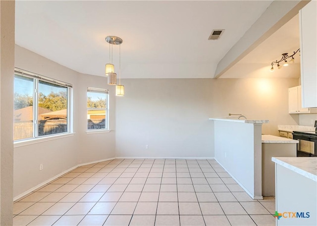 unfurnished dining area with vaulted ceiling and light tile patterned flooring