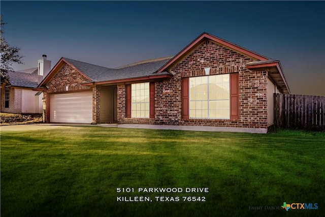 view of front of house with a garage and a lawn