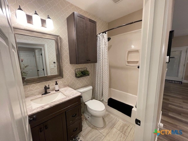 full bathroom with hardwood / wood-style floors, vanity, toilet, and shower / tub combo