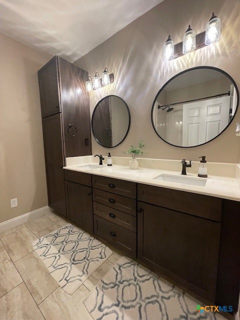 bathroom with a shower, vanity, and tile patterned floors