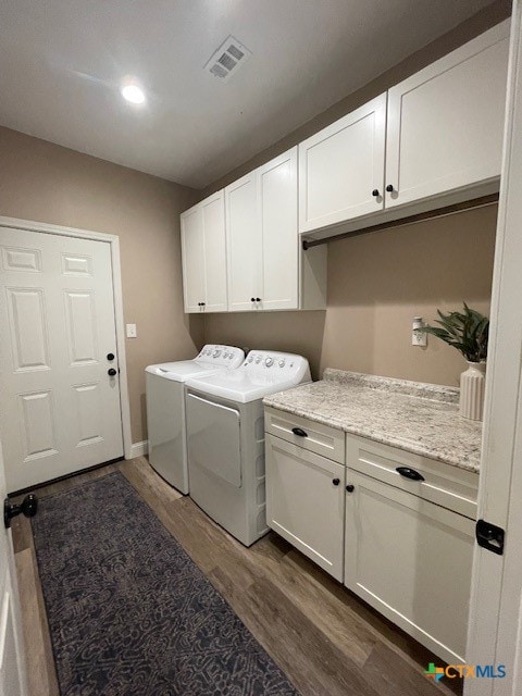 washroom with cabinets, dark hardwood / wood-style floors, and washer and clothes dryer