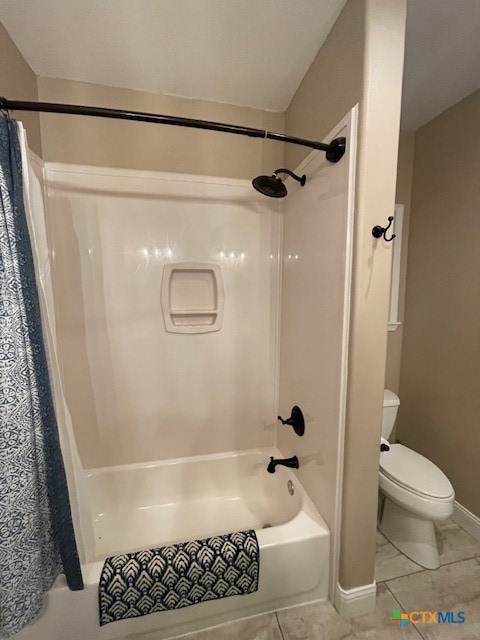 bathroom with toilet, shower / tub combo, and tile patterned flooring