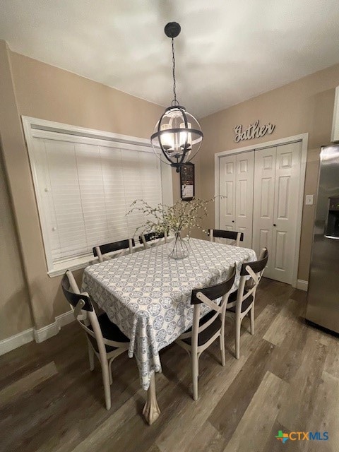 dining area featuring dark hardwood / wood-style flooring and a chandelier