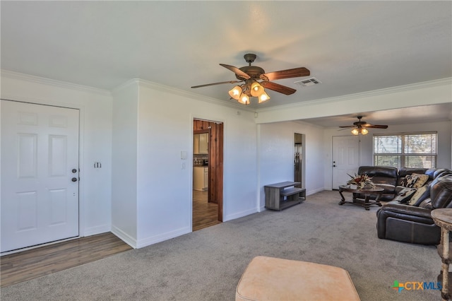 living room with hardwood / wood-style flooring, ceiling fan, and ornamental molding