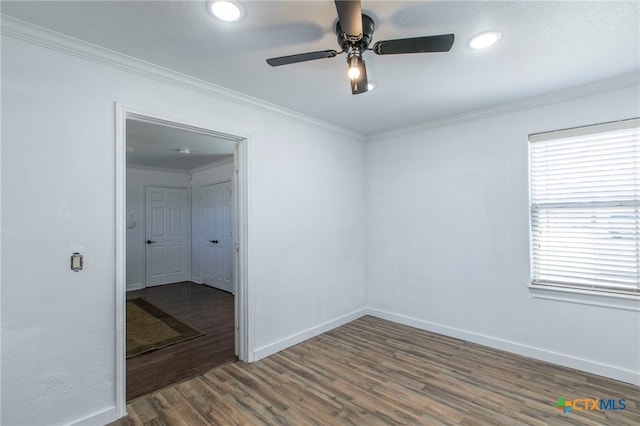 empty room featuring dark hardwood / wood-style floors, crown molding, and ceiling fan