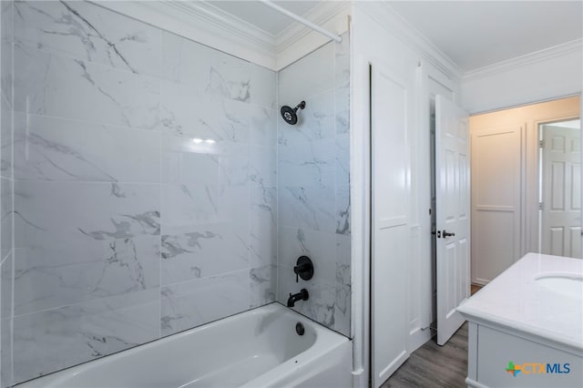 bathroom with vanity, tiled shower / bath, wood-type flooring, and crown molding