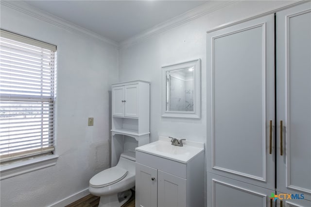 bathroom with ornamental molding, vanity, a healthy amount of sunlight, and toilet