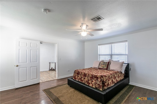 bedroom with dark wood-type flooring, ceiling fan, a textured ceiling, and crown molding