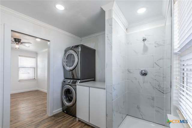 laundry room featuring stacked washing maching and dryer, ceiling fan, crown molding, and dark hardwood / wood-style flooring