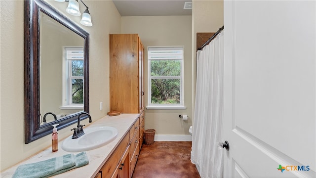 bathroom featuring vanity, a healthy amount of sunlight, and toilet