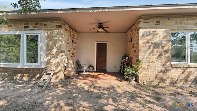 view of exterior entry with a patio and ceiling fan