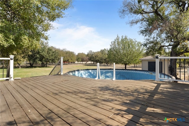 view of swimming pool featuring a deck and a yard