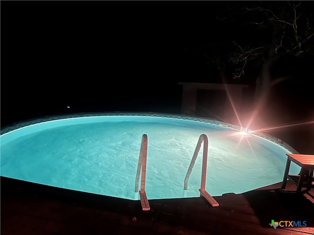 view of pool at twilight