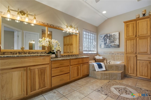 bathroom featuring tile patterned floors, tiled bath, vanity, and lofted ceiling