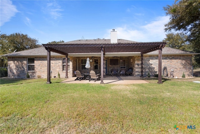 back of property with a lawn, a patio area, and a pergola