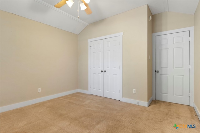 unfurnished bedroom featuring a closet, light colored carpet, ceiling fan, and lofted ceiling