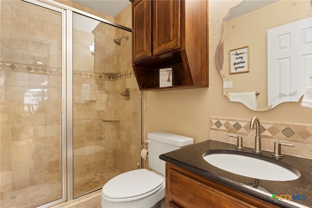 bathroom featuring vanity, toilet, and an enclosed shower