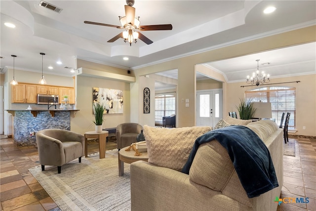 living room with french doors, crown molding, and a tray ceiling