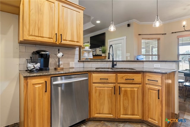 kitchen featuring backsplash, dishwasher, sink, and hanging light fixtures