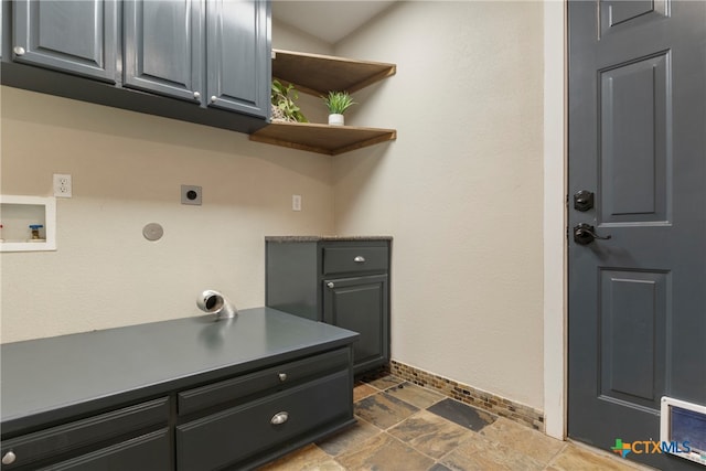 laundry area with hookup for an electric dryer, hookup for a washing machine, and cabinets