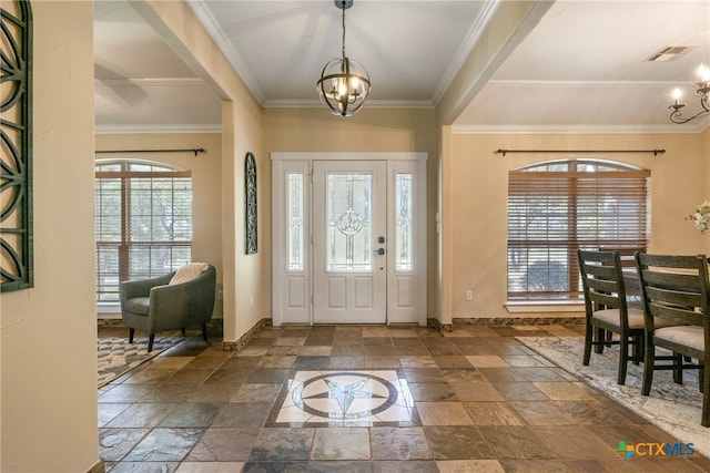 foyer featuring ornamental molding, plenty of natural light, and a notable chandelier