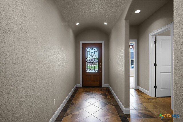 entryway featuring lofted ceiling and a textured ceiling