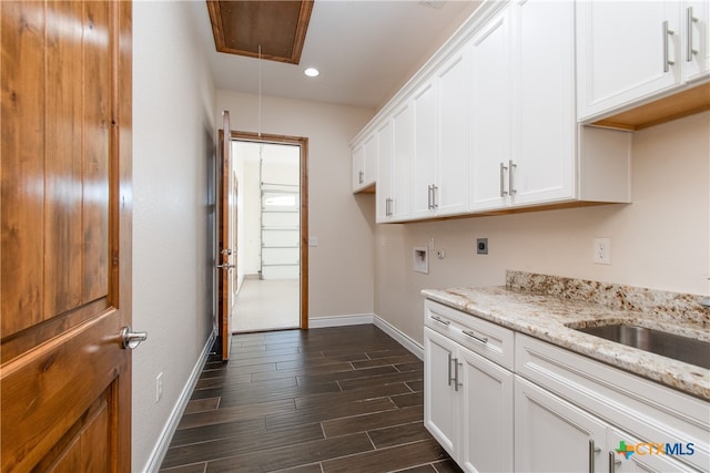 clothes washing area featuring cabinets, hookup for a washing machine, electric dryer hookup, and dark wood-type flooring